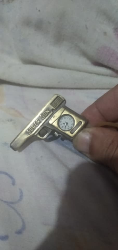 llavero con forma de pistola que incorpora un reloj